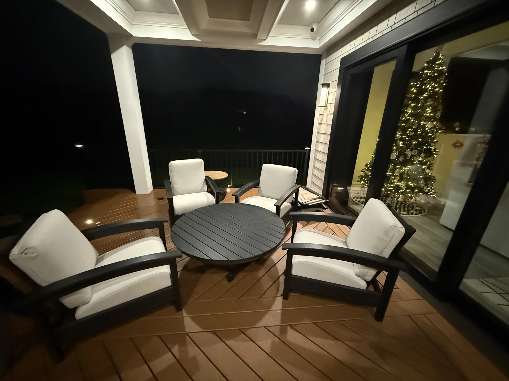 Covered deck dining area with evening lighting