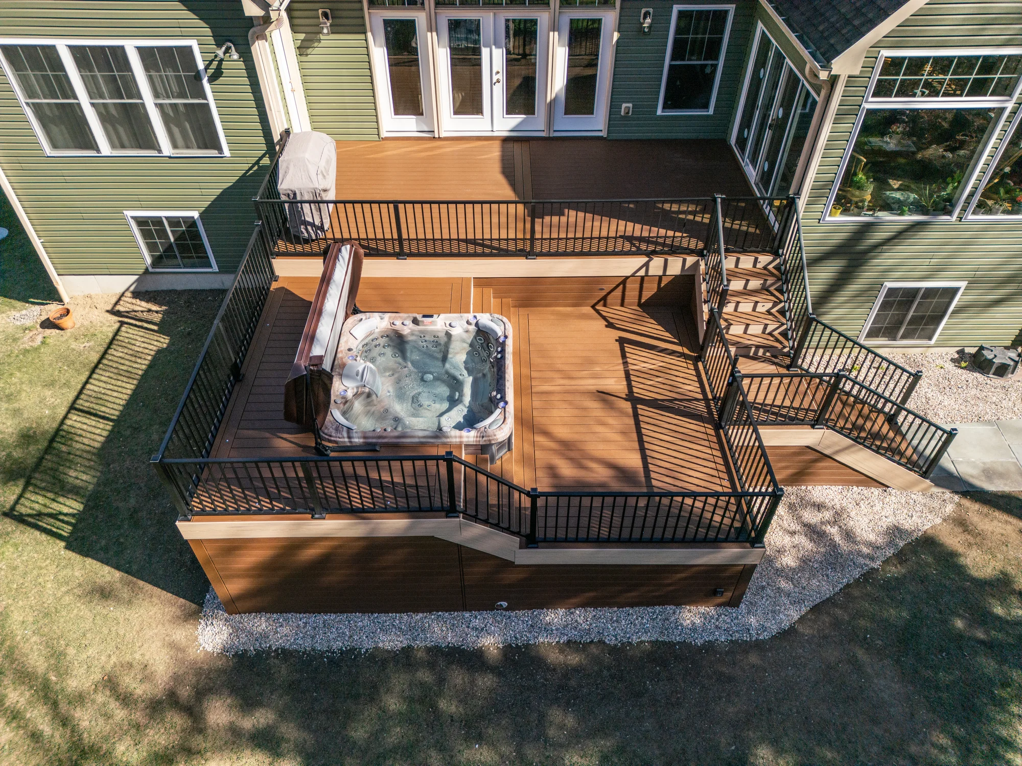 Covered deck with a hot tub and pergola seating area
