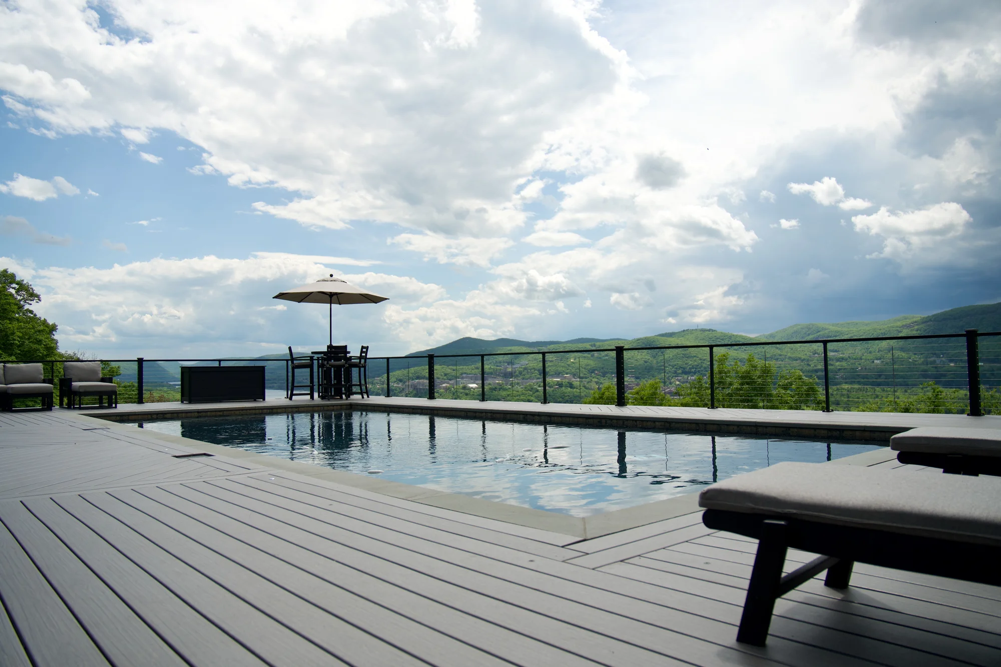 Infinity-edge pool with cable railing and a mountain view